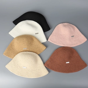 Flat lay of hand-knitted crochet bucket hats in six various colors for sun protection