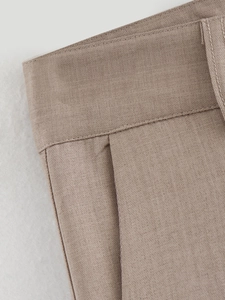 Macro view of light khaki woven fabric texture with precise stitching on the waistband