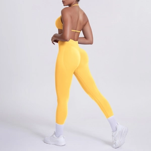 Vista laterale del set yoga giallo con pantaloni a vita alta e reggiseno halter