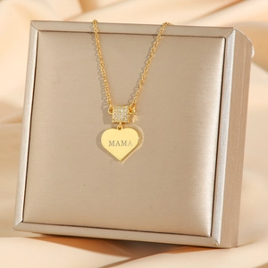 Golden heart necklace with MAMA engraving and zircon pavé on champagne silk display