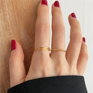 Detail of 925 sterling silver rings set with layered crossover and twisted gold bands