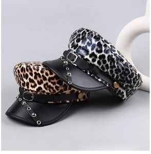 Detail view of leopard print flat top caps with faux leather brims and metal rivet studs