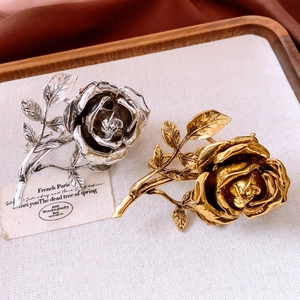 Detailed macro view of vintage gold and silver rose flower rings with relief petals