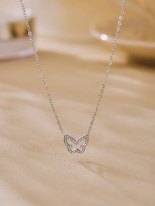 Macro shot of silver butterfly necklace pendant with pavé cubic zirconia inlay