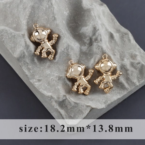 Colgantes de astronauta chapados en oro 18k de 18,2mm x 13,8mm sobre textura de piedra gris