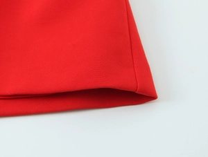 Detailed view of the red dress hem showing precise stitching and stretch fabric texture