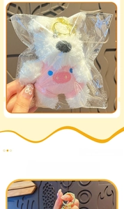 Detailed view of white Westie plush keychain in pink pig outfit with gold ring