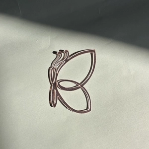 Détail macro du décor de papillon creux imprimé en 3D avec texture bronze et art linéaire