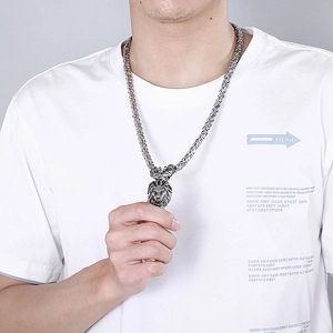 Close-up of men's shield lion head pendant on thick silver stainless steel chain necklace