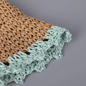 Macro detail of hand-woven straw hat showing brown fibers and light blue wavy trim edges