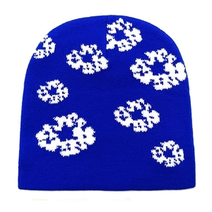 Macro detail of navy blue knitted beanie with white floral jacquard pattern