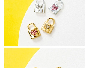 Macro shot of heart-shaped lock pendants with pink and white rhinestones in gold and silver