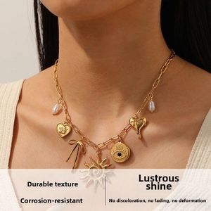Close-up of gold-plated necklace featuring multi-element heart and evil eye charms