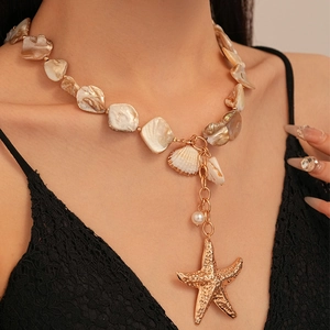 Close-up of ocean-style necklace with beige shells, golden starfish and pearl pendant