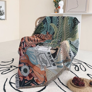 Close-up of bohemian woven throw blanket with tiger and leaf patterns and fringe detail