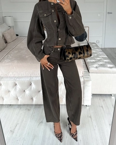 Detail der eng anliegenden braunen Jeansjacke und Weitbeinhose mit Leoparden-Accessoires