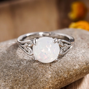 Detailed macro view of silver ring featuring white faux opal and hollow heart pattern