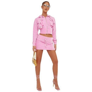 Pink velvet two-piece hoodie and mini skirt set worn by model for chic street style
