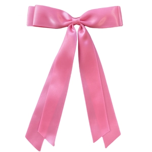 Detail of pink satin bow hair clip with long ribbons on a clean white background
