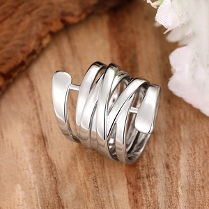 Dettaglio dell'anello a spirale multistrato argento con finitura lucida su legno