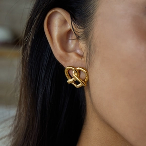 Elegant gold titanium heart twist earrings worn by model for a luxury stainless steel look