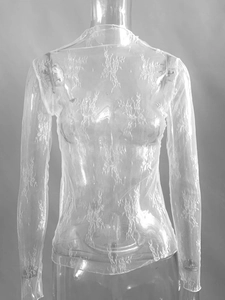 Détail du haut transparent en tulle blanc montrant les motifs de dentelle florale