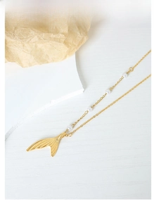 Detailed view of the gold mermaid tail pendant with elegant white pearls on the chain