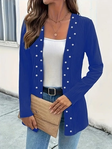 Detail of royal blue ribbed cardigan with elegant white pearls along the front opening