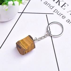 Macro view of a natural tiger eye stone keychain with brown fibrous texture and silver ring