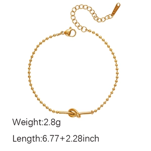 Macro detail of 18K gold-plated beaded steel bracelet with central knot and S.STEEL stamp
