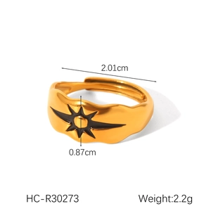 Detailed view of adjustable gold star ring with black star motif and wavy edges