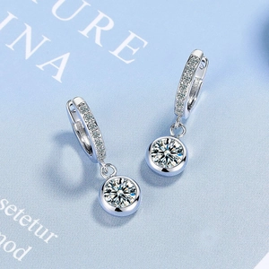 Detailed close-up of sparkling zircon hoop earrings with silver geometric round pendant
