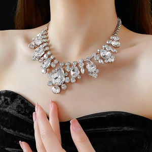 Close-up of a silver statement necklace with teardrop crystals on a model's neck