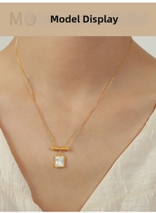 Detail of model wearing a 18K gold-plated square necklace with white mother of pearl inlay