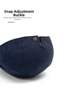 Close-up of adjustable bronze metal buckle on navy blue cotton linen flat cap