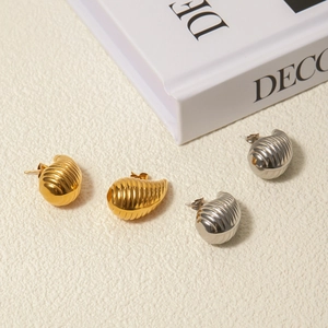 Detailed view of striped teardrop earrings in polished gold and silver finishes