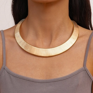 Close-up of golden metal choker with vintage vertical texture on a female model