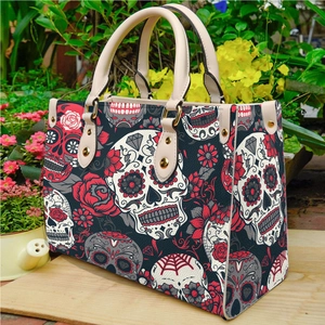 Vintage sugar skull and red rose print tote bag with white handles in a garden setting