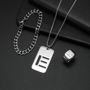 Makroaufnahme von silbernem Titanschmuck-Set mit E-Anhänger und eleganter Gliederkette