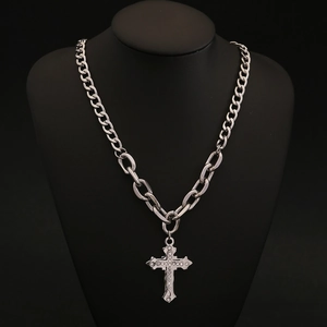 Dettaglio della collana a croce argento con cristalli su un manichino nero