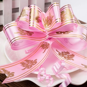 Close-up of pink satin wedding bow with golden double happiness symbols on a plate