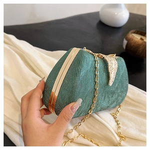 Detail of glittery peacock green box clutch with golden leaf clasp and chain strap
