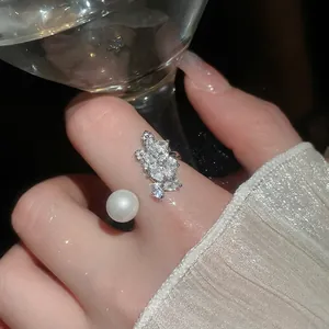 Bowtie zircon and pearl open ring with leaf cluster design on a silver finish band