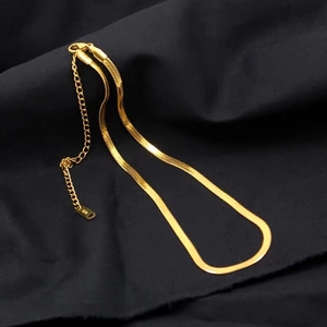 Detail of flat golden herringbone snake chain necklace with lobster clasp and extender