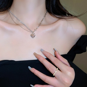 Close-up of sparkling heart pendant and matching star necklace set on a fashion model