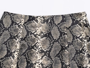 Close-up of animal snake print on elegant satin midi skirt with black and grey texture