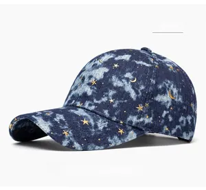 Detail of dark blue denim baseball cap with gold embroidered star and moon patterns