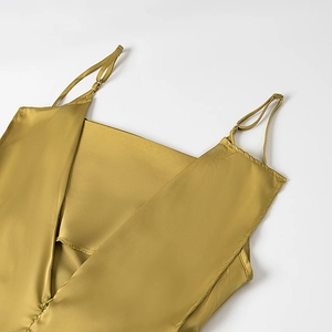 Detail of ginger yellow satin slip dress featuring adjustable spaghetti straps and smooth silk-like texture