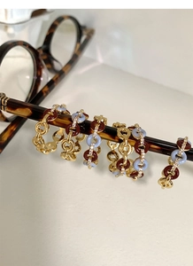 Detail of vintage gold rings with enamel and zircons hanging on eyewear arm