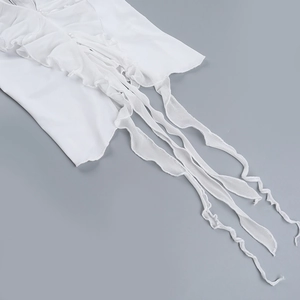 Detail of white ruffled halter top featuring delicate chiffon fabric and pearl button accents